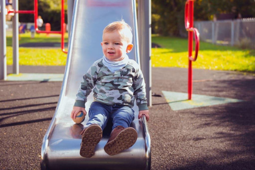 Families portfolio - a little boy on the bottom of a slide