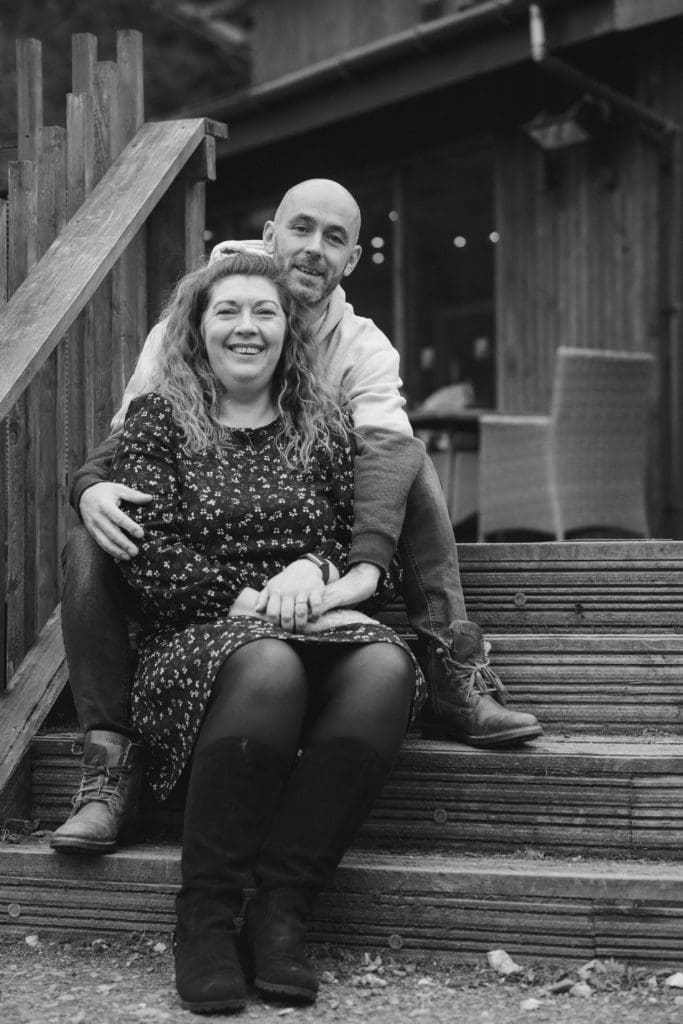 Engagements Portfolio - B&W of a couple sitting on some steps embracing