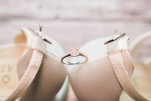 wedding photographer in Bedfordshire - a close up of the back of cream bridal shoes with her engagement ring balancing between them