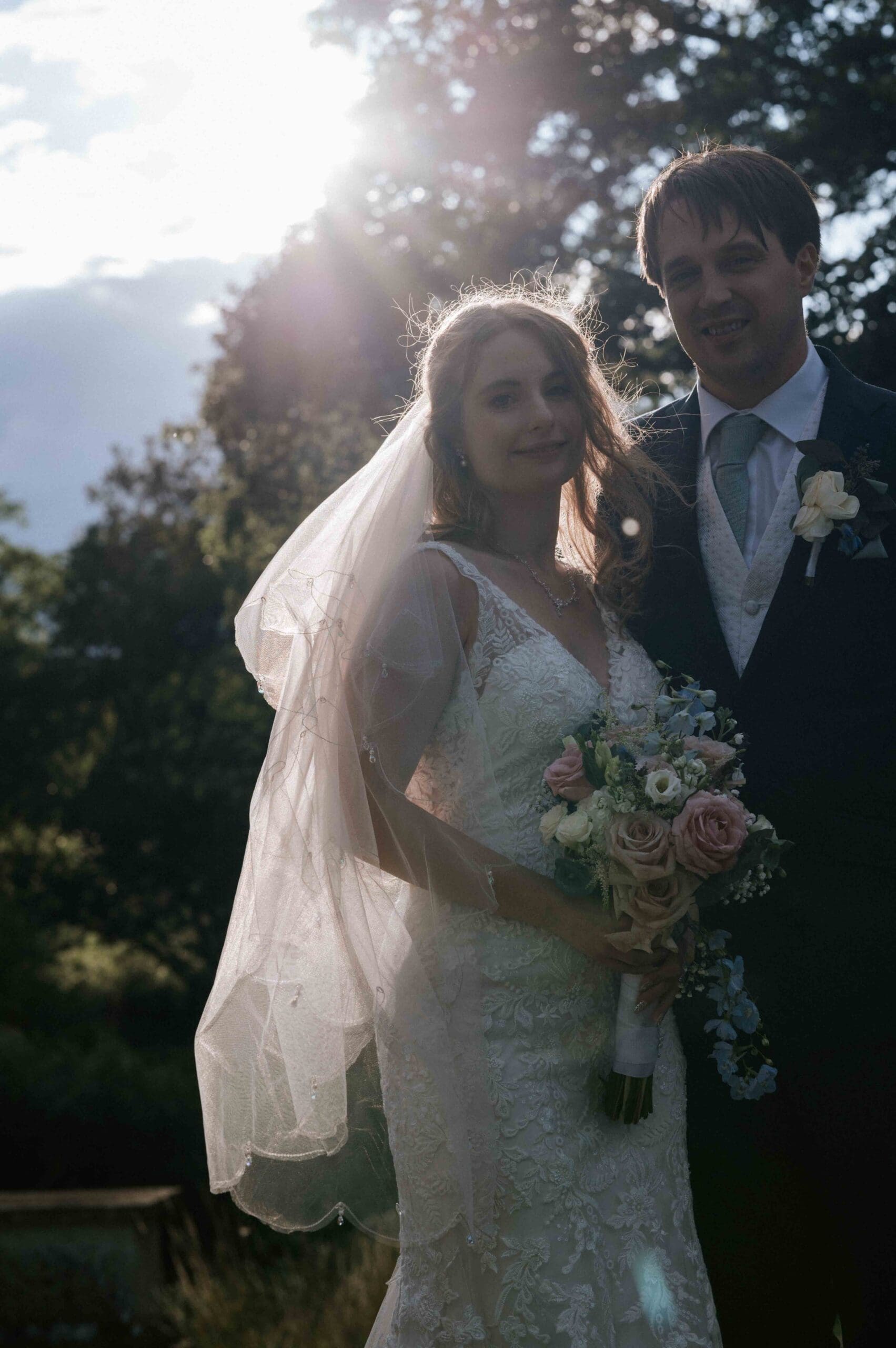 Contact Me - a bride and groom stand with the sun glowing behind them