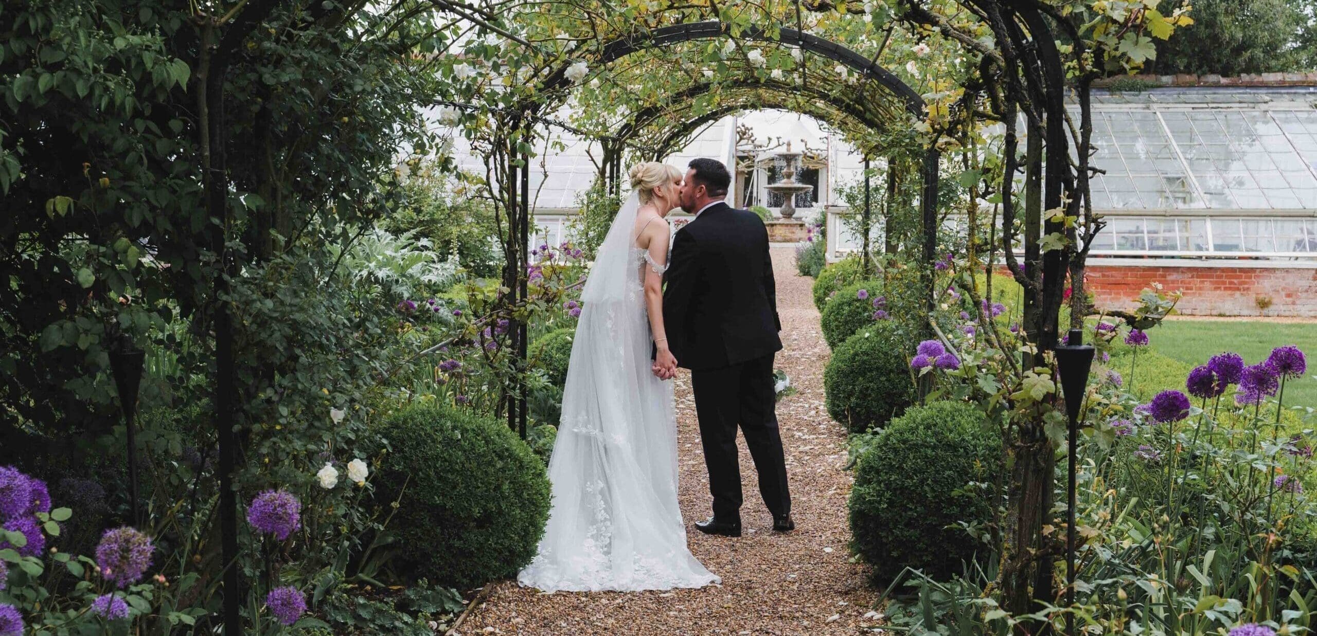 Bride & Groom kissing in the gardens at Braxted Park wedding venue